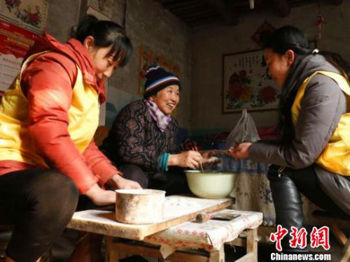 資料圖：除夕，巨鹿縣居家養老服務中心工作人員王勝晨、陳雲彩和失獨老人張會群一起包餃子。　王丙強 攝