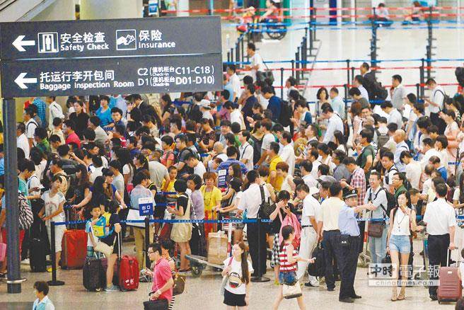 兩岸春節加班機明天上午8時開賣。圖為旅客去年春節期間在上海虹橋機場排隊換票。（臺媒取自新華社）