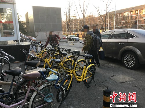 在北京街頭的一處共用單車停車點，有小孩在嘗試解鎖。湯琪 攝