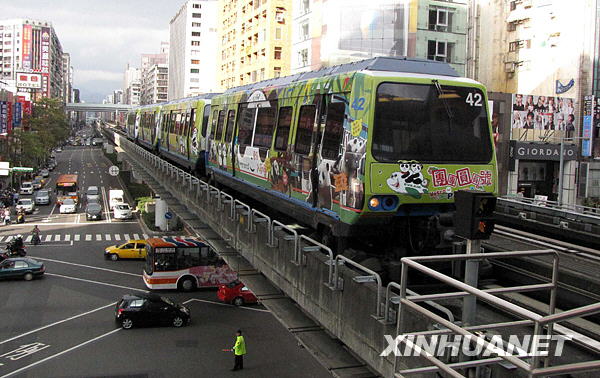 這是行駛在臺北街頭的“熊貓列車”（1月31日攝）。大熊貓“團團”“圓圓”1月26日農曆大年初一在臺北市立動物園公開亮相後，臺灣民眾爭睹大熊貓的風采。為了方便民眾，臺北捷運通往動物園的線路開通了熊貓彩繪列車，車廂上畫上了“團團”“圓圓”從出生、成長、到移居臺北動物園新家的全過程，列車每20分鐘發出一班。新華社記者王妍攝