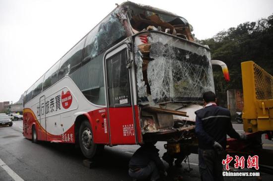 3月6日，臺灣一輛載有大陸旅遊團的遊覽車在新北市萬里區撞到民宅。據臺灣新北市消防局通報，車上23名大陸乘客和1名臺灣導遊均平安，但駕駛員失去生命跡象。圖為遊覽車被拖出事發點。<a target='_blank' href='http://big5.chinataiwan.cn/gate/big5/www.chinanews.com/'><p  align=