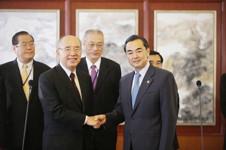 Wang Yi (R, Front), director of the State Council Taiwan Affairs Office, shakes hands with Kuomintang (KMT) Chairman Wu Poh-hsiung at the Beijing Capital International Airport in Beijing on May 25, 2009. A KMT delegation headed by Wu arrived in Beijing on Monday for an visit on the mainland.