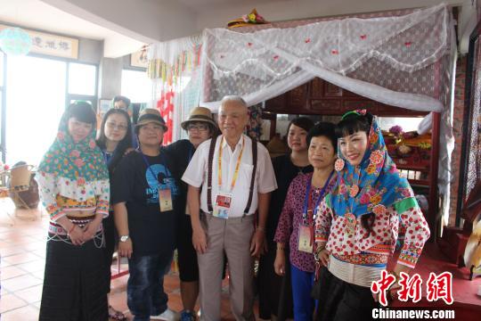 6月12日，來自臺灣基隆的8旬臺胞張細山回到祖籍地參觀村內的惠安女民俗風情園，攜家族成員與“惠安女”合影。　廖靜 攝