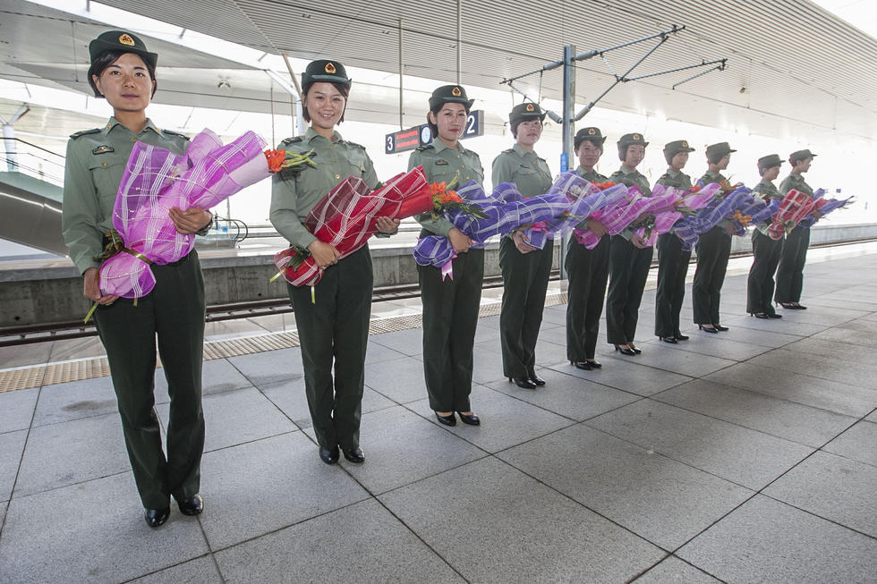 天安門參閱官兵乘專列回營 女兵捧花接站