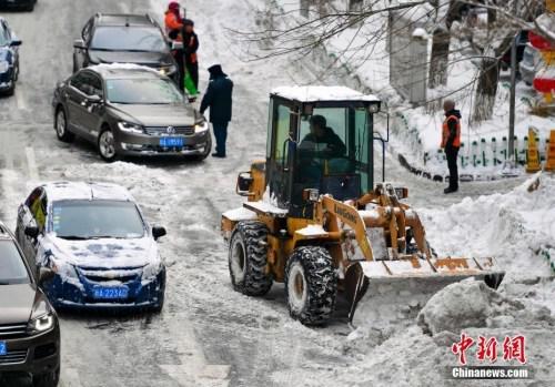 在烏魯木齊市區，大型機械設備出動清理道路上的積雪。 中新社記者 劉新 攝