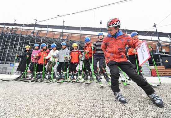 在四川省成都市新都區尖鋒旱雪四季滑雪場，教練曹建（前）為隊員們示範技術動作（2月25日攝）。新華社記者 王曦 攝