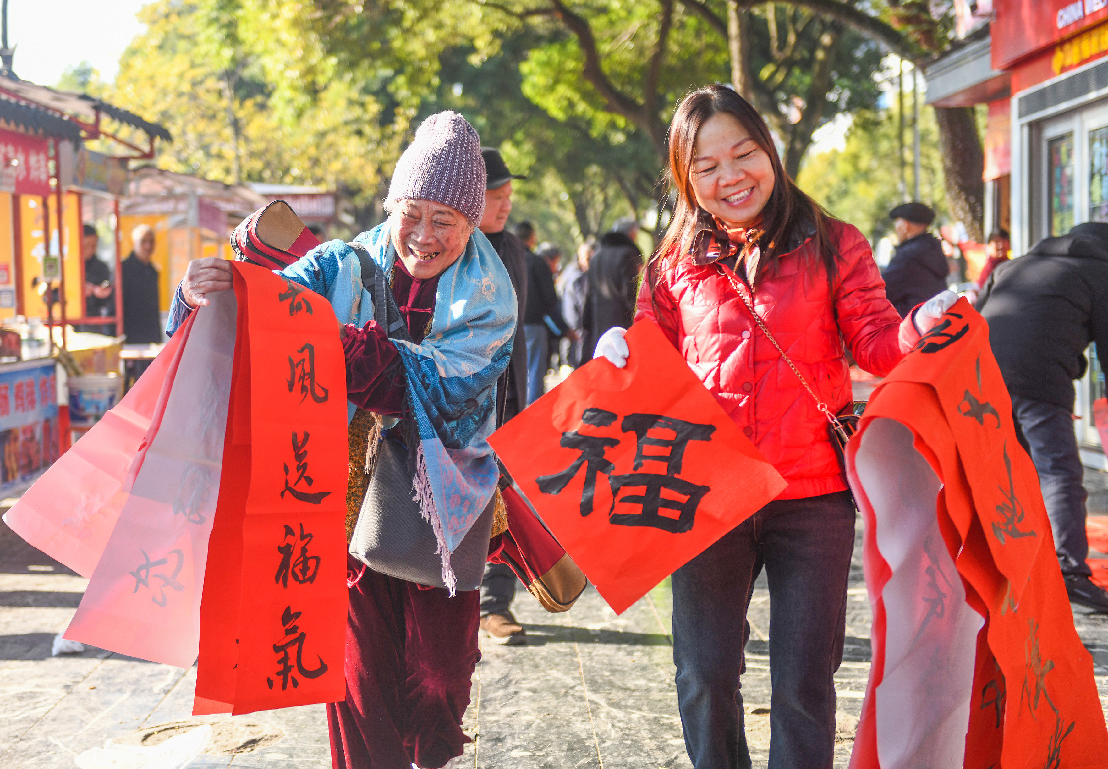 2025年1月13日，在湖南省永州市道縣西洲公園義工崗亭，市民們領到了書法志願者為大家書寫的春聯。