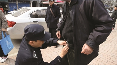 民警幫老人穿好褲子。