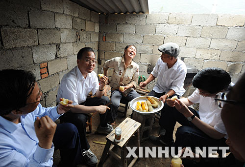 6月20日至22日，中共中央政治局常委、國務院總理溫家寶到受汶川大地震波及的陜西、甘肅災區檢查指導抗震救災工作，看望幹部群眾。這是6月21日，溫家寶在甘肅隴南市康縣豆坪鄉豆坪村與受災群眾一起吃馬鈴薯。 新華社記者黃敬文攝