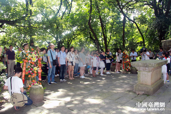 第12屆海峽兩岸媒體採訪團的記者和當地師生為73軍抗戰陣亡將士墓獻花