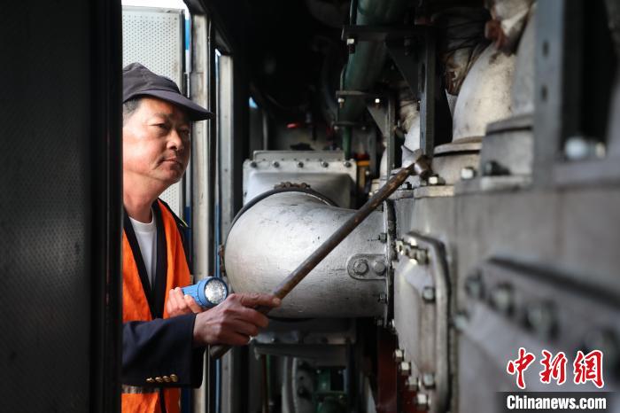 圖為出發前，何志剛檢查內燃機車內部情況。　孫嘉奎 攝