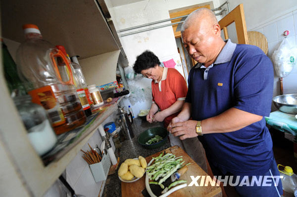 周開國和老伴在廚房裏忙活（9月9日攝）。