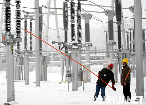 1月29日，安徽省淮北供電公司員工用絕緣棒清理電力設備上的覆冰和積雪。