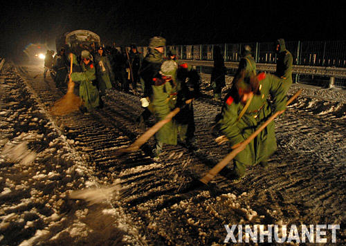 1月28日晚，武警戰士在推動陷入雪中的車輛。