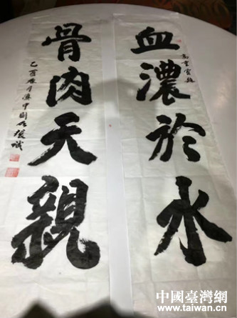 張誠先生揮毫書寫“血濃于水，骨肉天親”