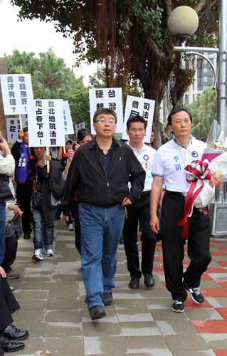 二次金改案，臺北地方法院判處陳水扁無罪。“立委”邱毅(前左)與民眾8日聚集在臺北地方法院，舉牌抗議