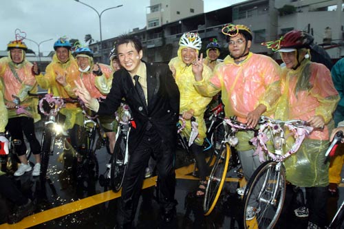 嘉義市民李旭嘉（西裝者）19日以自行車隊前往嘉義縣迎娶新娘洪禎彩，碰上颱風襲臺，風強雨大，過程雖然艱辛，但很甜蜜。