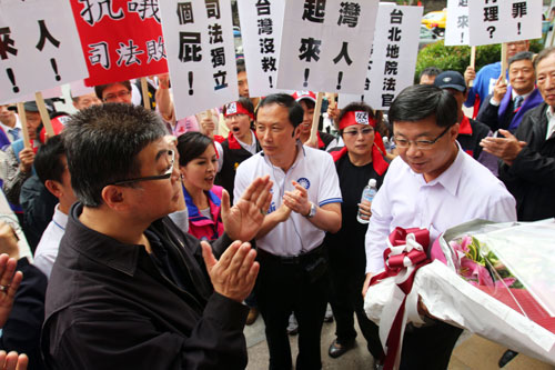 “立委”邱毅(前左)與民眾8日聚集在臺北地方法院，抗議二次金改案北院判決陳水扁無罪，並到“最高法院檢察署”獻花，為檢方加油打氣。