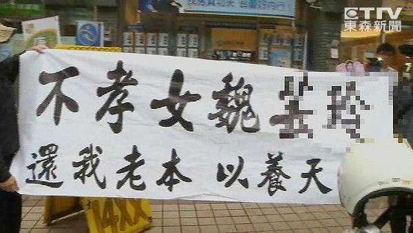 70歲老夫婦上街高舉白布條抗議女兒借200萬不還，害他們半年都繳不出健保費。（臺媒圖）