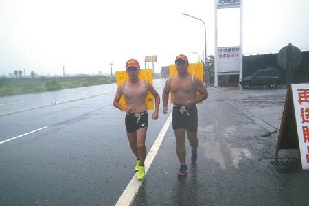 臺灣兩大學生不畏風雨 打赤膊背廣告牌慢跑環島(圖)