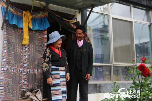 村民扎西多吉與妻子在新房子門口開心地交談