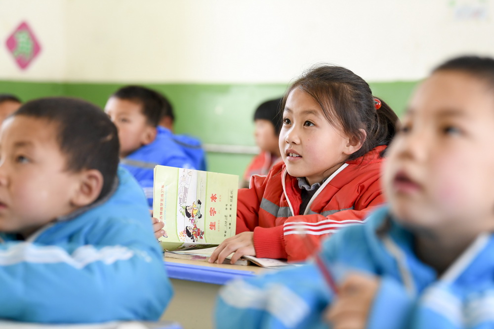 寧夏固原市西吉縣馬建鄉大坪小學一年級學生鐵嘉欣（右二）在課堂上學習（3月15日攝）。新華社記者 馮開華 攝