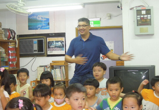 連勝文到幼兒園參訪，席地而坐和小朋友講故事。（臺媒圖）