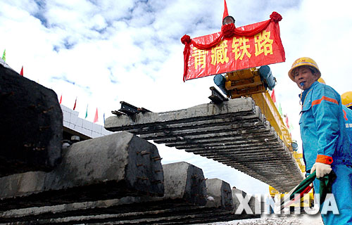 一名青藏鐵路建設者正在指揮鋪軌。2005年8月24日，隨著青藏鐵路在海拔5072米處成功鋪軌，中國人創造了世界鐵路最高點的紀錄（資料照片）。     青藏鐵路從西寧至拉薩全長1956公里，是世界上海拔最高、線路最長、穿越凍土里程最長的高原鐵路。把鐵路修進西藏是幾代中國人的夢想，但這一想法直到新中國成立後才逐漸變為現實。青藏鐵路一期工程西寧至格爾木段于1958年開工，1984年交付營運。但限于當時國家的經濟實力以及高原、凍土等築路技術難題尚未解決，格爾木至拉薩段被迫停建。2001年6月，國家總投資330.9億元動工修建青藏鐵路二期工程。這一工程跨越崑崙山、唐古拉山，通過多年凍土層和大片“生命禁區”，是人類鐵路建設史上亙古未有的穿越。它的建成將為神秘而古老的青藏高原帶來新的生機和活力！     新華社發