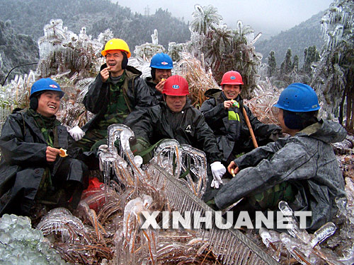 2月1日，電力工人坐在冰凍的地面上吃乾糧。自1月13日以來，廣西昭平縣遭遇持續強冰凍災害襲擊，造成山上大批電力設施和電網被損。災情發生後，該縣300多名電力工人日夜搶修設施和線路，確保全縣生産和生活用電。