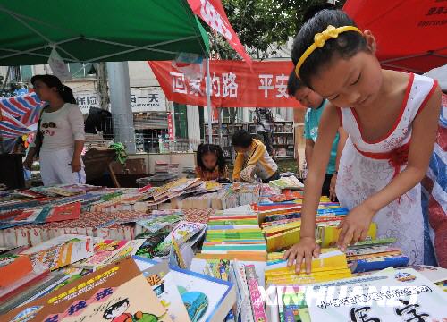  6月7日，一位小朋友在綿竹市街頭的綿竹市圖書館臨時閱覽點看書。     記者在四川地震災區看到，災區群眾沒有被災難壓垮，他們的生活正在從災難中逐步恢復起來，災區處處展露生機。 　