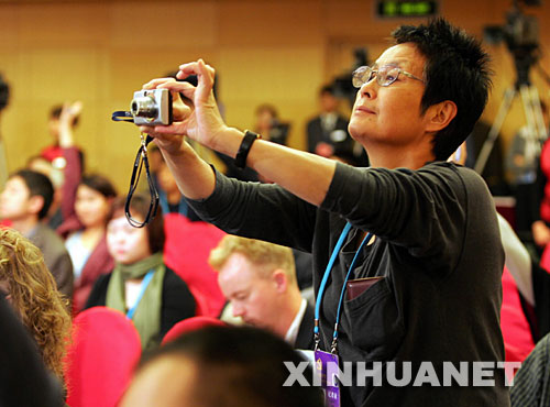 一位記者在十七大新聞中心拍攝（10月17日攝）。 新華社記者 殷剛 攝