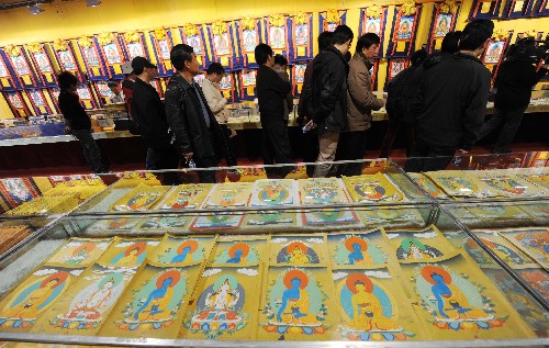 4月12日，援藏幹部在西藏崗地經貿有限公司唐卡展示中心參觀。 當日，來自國家各部委的120多名援藏幹部來到西藏國家級文化産業示範基地——西藏崗地經貿有限公司參觀。近年來，隨著西藏旅遊業的迅速發展，文化産業得到空前發展。西藏崗地經貿有限公司作為西藏文化産業的龍頭企業，文化藝術産品深受國內外遊客的青睞。 新華社記者 格桑達瓦 攝